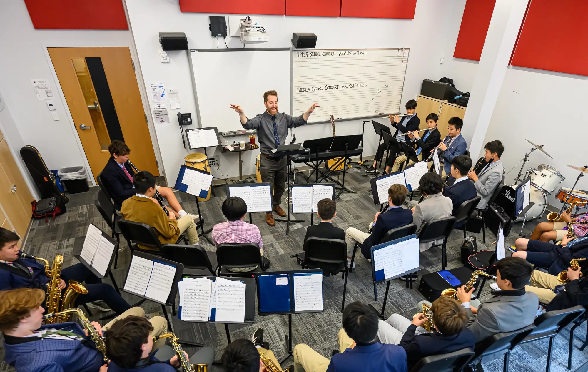 Un director de orquesta dirige una pequeña banda de estudiantes de secundaria