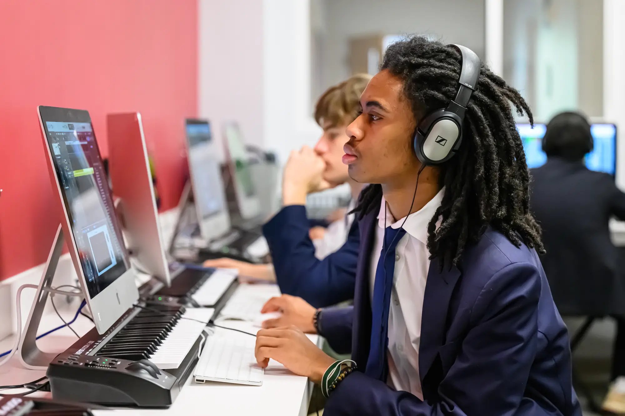 Un adolescente trabaja con un teclado midi durante una clase de música