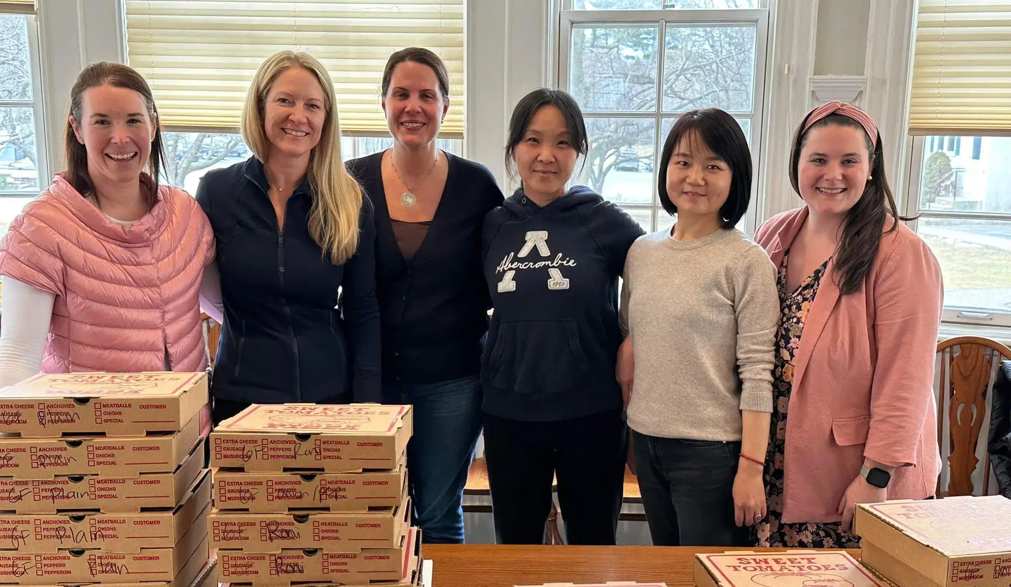 Agradecimiento al personal docente: mujeres detrás de cajas de pizza