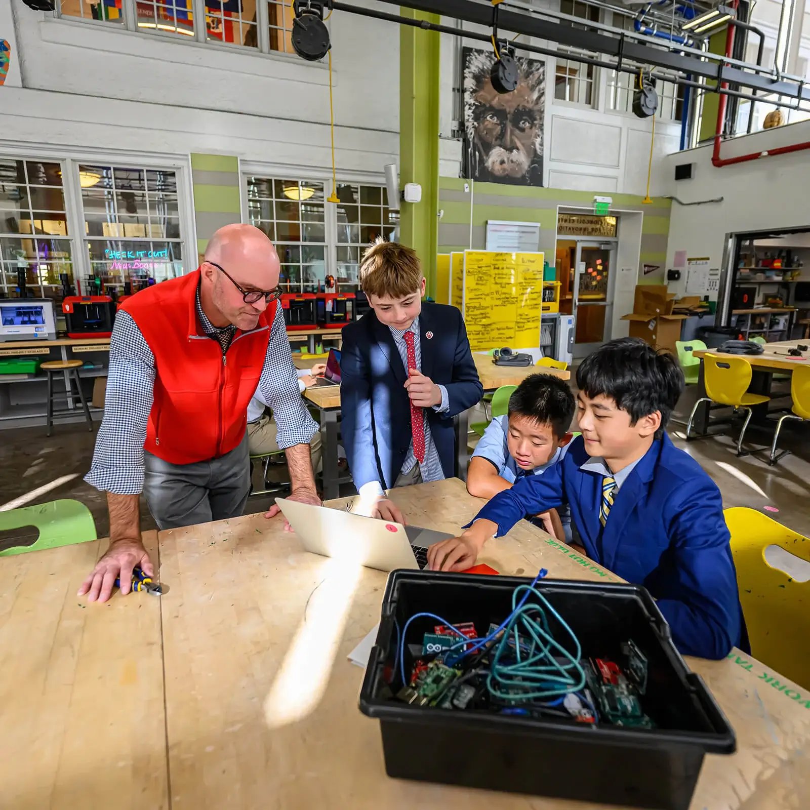 Chicos y profesor trabajando juntos en un proyecto en el Centro de Innovación