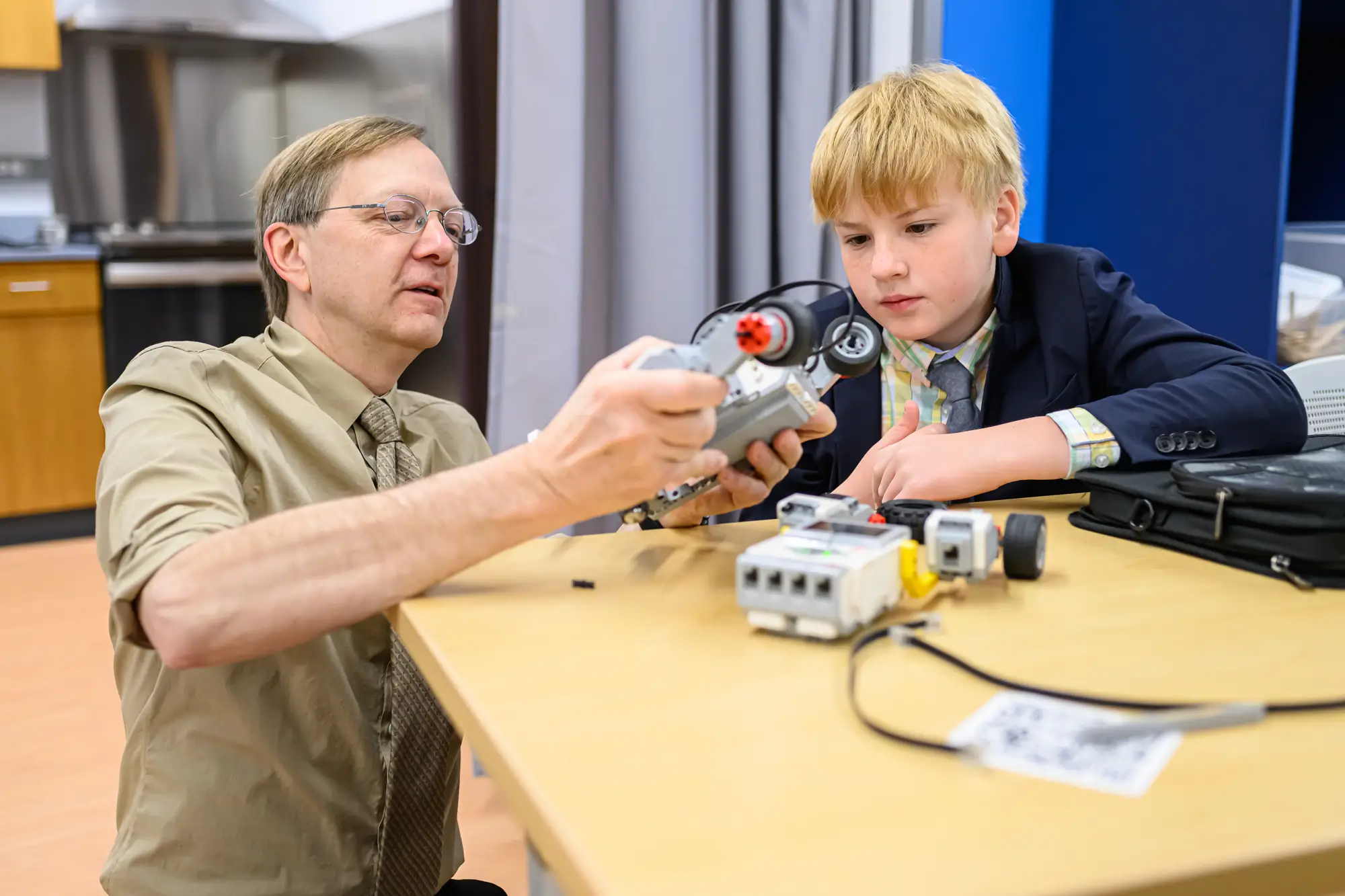 Science Bob ayuda a un alumno de secundaria con un proyecto de robóticaun profesor ayuda a un alumno con un proyecto de ciencias